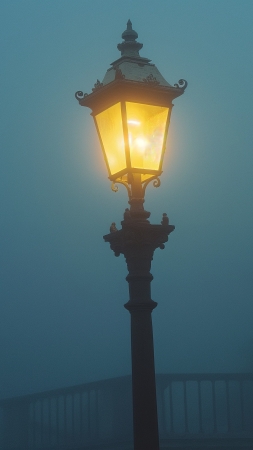 Street lamp in the fog wallpaper, misty atmosphere, streetlight glow, background for mobile wallpaper (vertical)